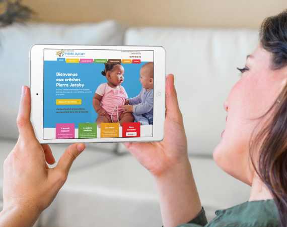 une femme regardant sur sa tablette le nouveau site internet de la crèche Pierre Jacoby